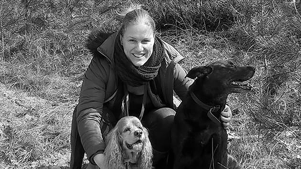 Een vrouw met twee honden. Het beeld is zwart-wit.