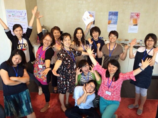 Een groep aziatische vrouwen staan erg vrolijk op de foto.