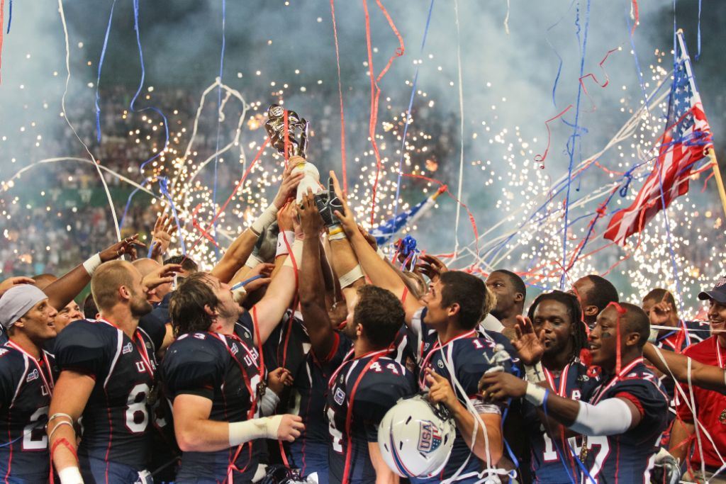 Een rugby team dat een beker met zijn alle omhoog houdt. Op de achtergrond is er vuurwerk en confetti.