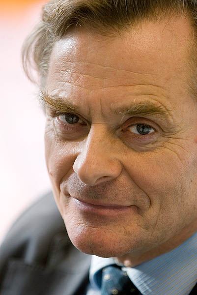 Een close-up van Jan Walburg, een man met blauwe ogen en bruine haren, kijkt in de camera.