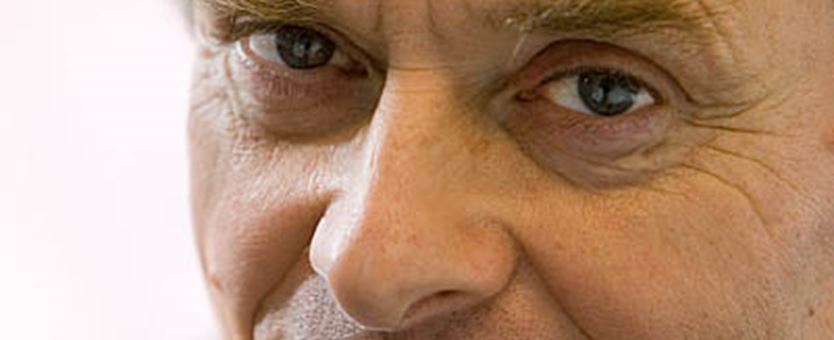 Een close-up van Jan Walburg, een man met blauwe ogen en bruine haren, kijkt in de camera.